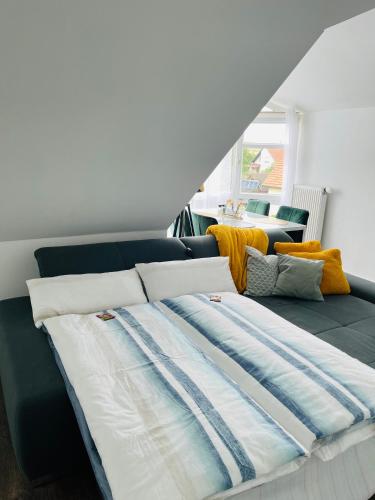 a large bed in a room with a couch at Ferienwohnung Moments klimatisiert in Balingen