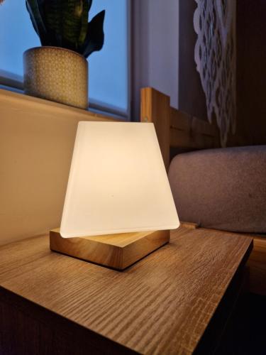 a light on top of a wooden table at Apartament Strzyżowiec 80 in Czernica