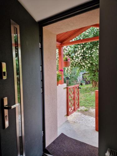 an open door to a garden with a gate at Apartament Strzyżowiec 80 in Czernica