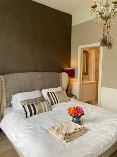 a white bed with a tray of flowers on it at Vondelpark Suite in Amsterdam
