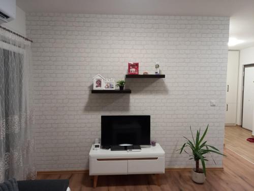 a living room with a tv on a white brick wall at Sweet home in Brčko