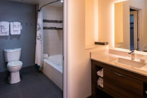 a bathroom with a toilet and a tub and a sink at Residence Inn by Marriott Temecula Murrieta in Murrieta