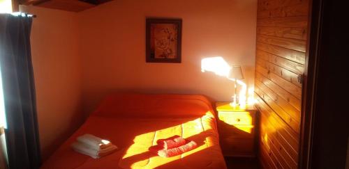 a small bedroom with a bed and a lamp at El Maiten Bariloche in San Carlos de Bariloche