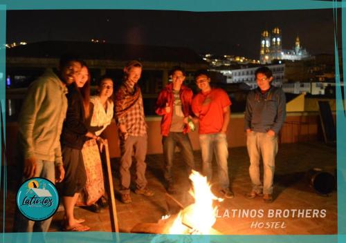 een groep mensen die rond een vuur op een dak staan bij Latinos Brothers House in Quito