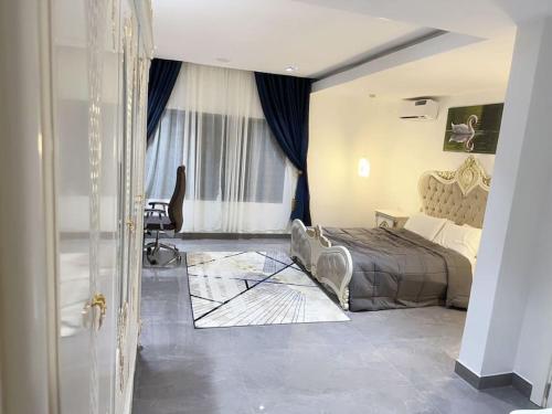 - une chambre avec un lit et une chaise dans l'établissement Brand New Exclusive Condo with Pool and Gym, à Port Harcourt