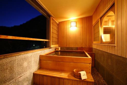 a bath tub in a room with a window at Jozankei Daiichi Hotel Suizantei in Jozankei