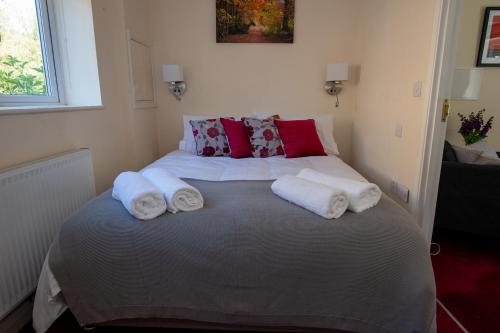 a bedroom with a large bed with towels on it at Entire apt. quiet area near Leeds Castle Maidstone in Harrietsham