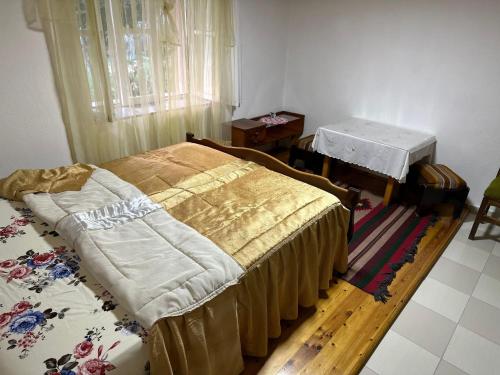 a bedroom with two beds and a table in it at Gardenhouse in Mëmëlisht