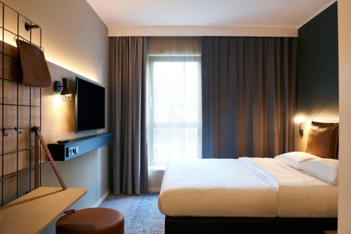 a hotel room with a bed and a window at Moxy Essen City in Essen