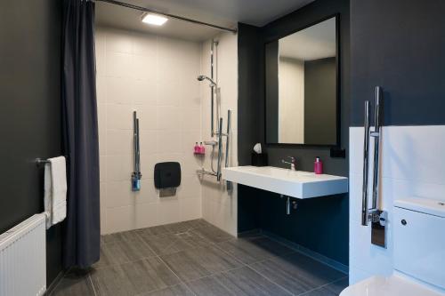 a bathroom with a sink and a shower at Moxy Essen City in Essen