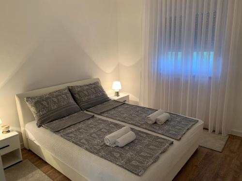a white bedroom with a bed with two pillows at Sweet Retreat on Buna Riverside - with private pool in Blagaj