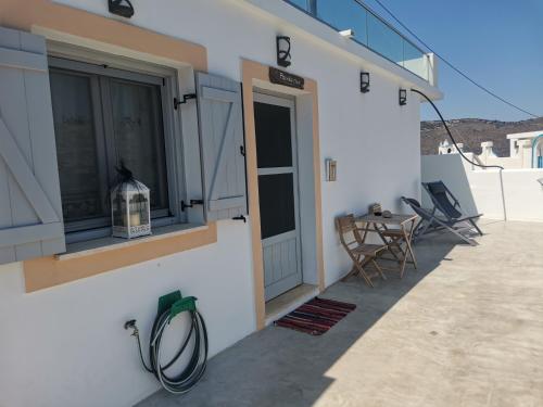 un balcón de una casa con mesa y sillas en Pandaisia Φούρνοι Κορσεων, en Fourni Ikarias