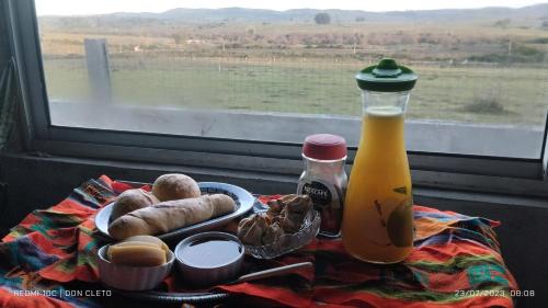 a table with a plate of food and a bottle of juice at Don Cleto "La Mimosa" in Aiguá