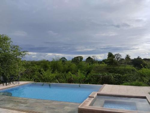a swimming pool with a view of a field at Encanto cafetero quimbaya in Quimbaya