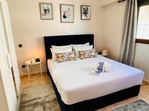 um quarto com uma grande cama branca com almofadas em Appartement Cosy quartier chic de Rabat em Rabat