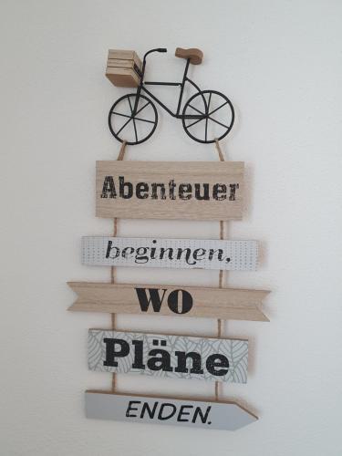 a wooden sign with a bike on a wall at MV Römervilla, Lofts & Penthouses mit traumhaftem Moselpanoramablick und Sauna in Treis-Karden