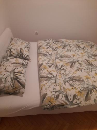 ein Bett mit einer Decke und zwei Kissen darauf in der Unterkunft Apartman Nina in Banja Luka