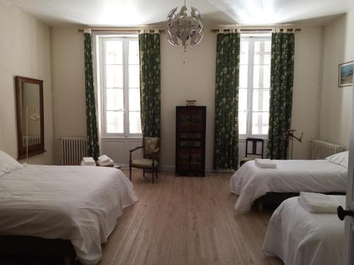 1 Schlafzimmer mit 2 Betten und einem Kronleuchter in der Unterkunft Domaine de Pladuc in Lachaise