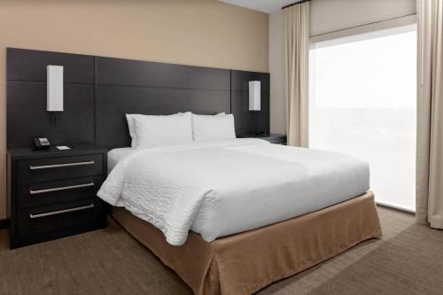 a bedroom with a large bed and a large window at Residence Inn by Marriott Phoenix Mesa East in Ciela Grande Mobile Home Park