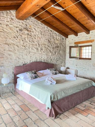 een slaapkamer met een groot bed in een stenen muur bij Le Mansarine Charme B&B in Castellaro