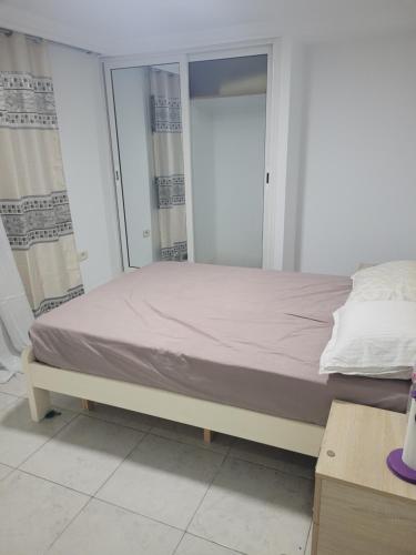 un letto in una stanza bianca con di Maison S1 a Mahdia