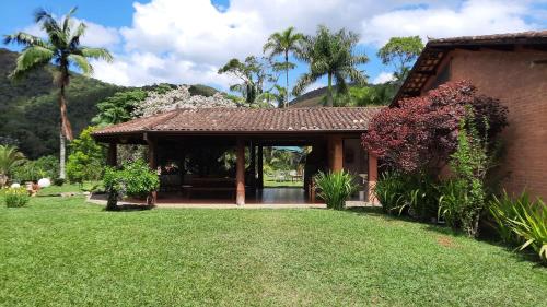 a house with a pavilion in a yard at Fazenda Maria Faceira in Monteiro Lobato