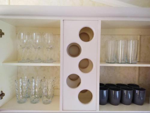 a white cabinet with glass vases and glasses at Lake District Holiday Home, near Ennerdale Lake - Inglenook 06 - Free Wifi in Workington