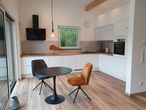 a kitchen with a table and two chairs and a table at MV Römervilla, Lofts & Penthouses mit traumhaftem Moselpanoramablick und Sauna in Treis-Karden