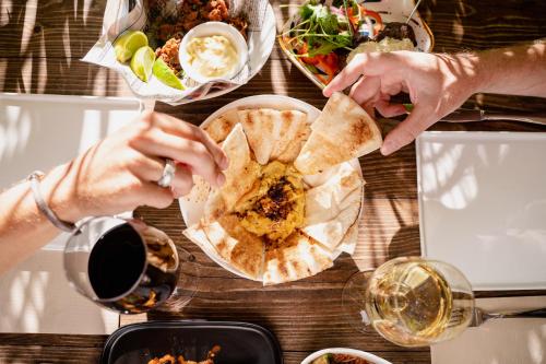 a group of people sitting at a table eating food at BOHO Bohemian Boutique Hotel in Willemstad