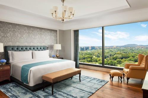 浦那的住宿－The Ritz-Carlton, Pune，一间卧室设有一张床和一个大窗户