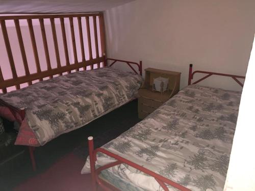 una camera con due letti e un comodino accanto ad esso di DUPLEX ALCAZABA con parking gratuito, 2 dormitorios , 5pax a Sierra Nevada