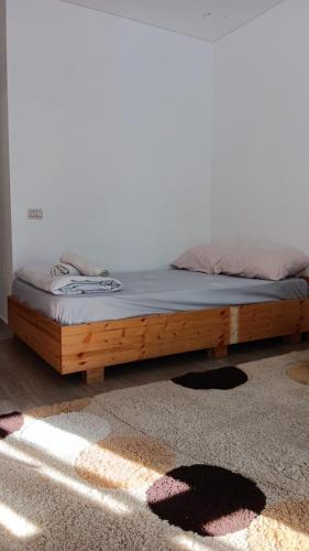 een bed met een houten frame in een kamer bij Jamie's Guest House in Roşu