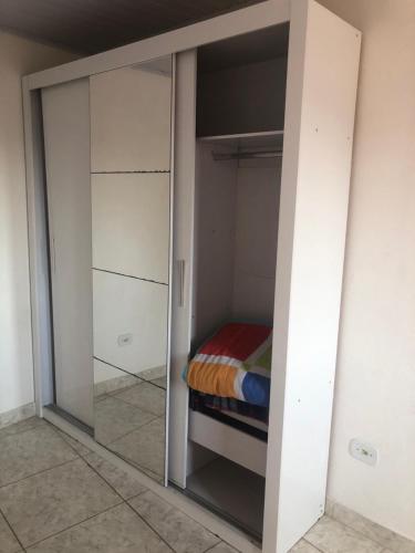 um armário com uma porta de vidro com uma cama em Apto sereno próximo a Expo São Paulo! em São Paulo