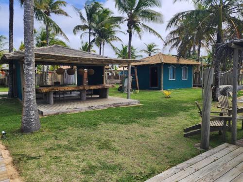 uma casa com um deque e um quintal com palmeiras em Nuhatê Casa Hotel em Caraíva