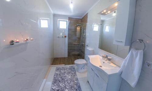 a white bathroom with a sink and a shower at Sweet Retreat on Buna Riverside - with private pool in Blagaj