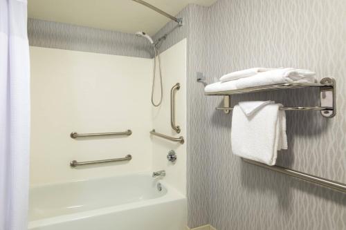 a bathroom with a shower and a bath tub with towels at SpringHill Suites Louisville Downtown in Louisville