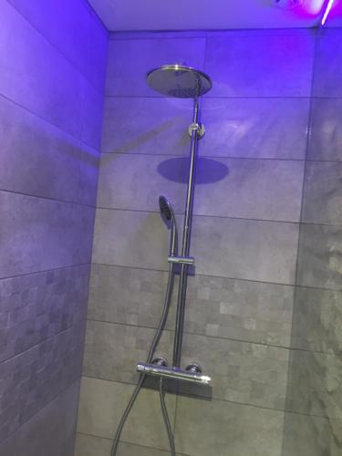 een douche met paarse verlichting in de badkamer bij Saint-Louis : Saint-Étienne appart de 125 m2 centre-ville 4 chambres,4 lits king size in Saint-Étienne