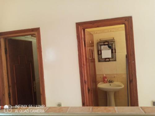 y baño con lavabo y espejo. en شقة ببزنيقة, en Bouznika