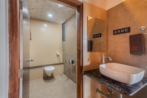 een badkamer met een wastafel en een toilet bij SaffronStays Willowbrook Arbor, Nashik in Nashik