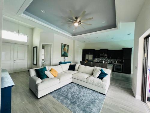 a living room with a white couch and a ceiling at Newly built Villa Ballerina with heated pool and incredible view into beautiful Arrowheadcanal in Cape Coral