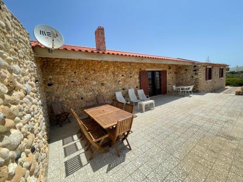 a stone building with a table and chairs on a patio at Casa dos Rebolinhos in Sagres