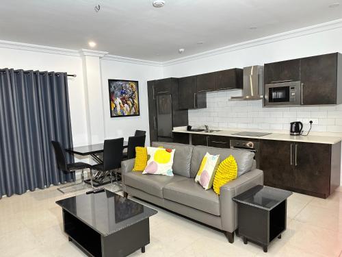 a living room with a couch and a kitchen at Westlands Tower - Ghana Villas in Accra