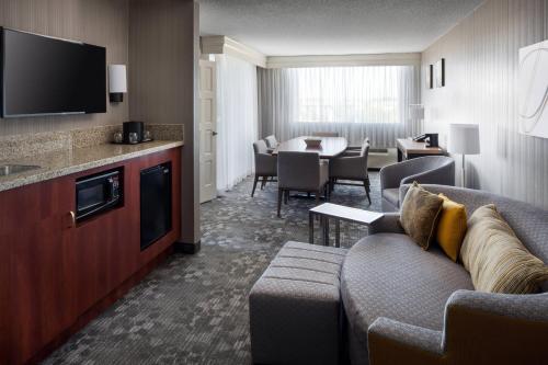 a living room with a couch and a dining room at Courtyard by Marriott Richmond Berkeley in Richmond