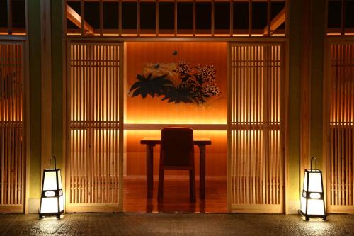 a table with a chair in a room with two lights at Jozankei Daiichi Hotel Suizantei in Jozankei