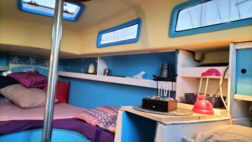 a bedroom in a boat with a bed and windows at La Perle d'orient A man donné in Gruissan