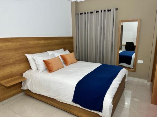 1 dormitorio con 1 cama grande y espejo en Westlands Tower - Ghana Villas, en Accra