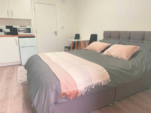 a bedroom with a large bed with pink pillows at Studio flat private bathroom wc and kitchenette in London