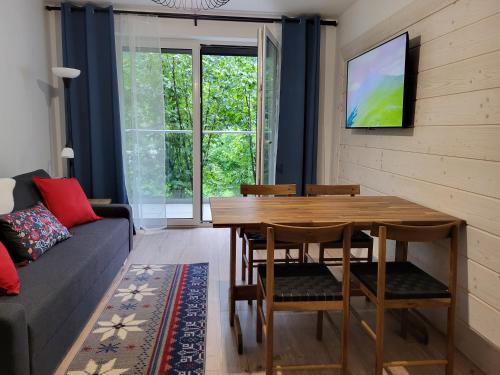 a living room with a wooden table and a couch at Villa Olimpijska 2 - Centrum in Wisła