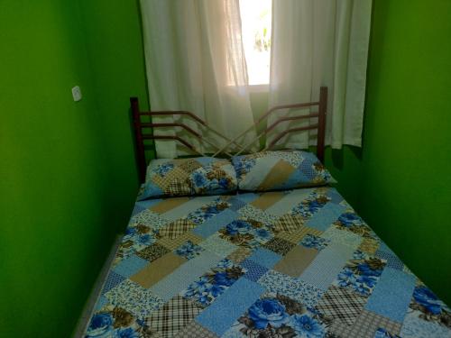 a bedroom with a bed with a quilt on it at Chale 8A in Cunha