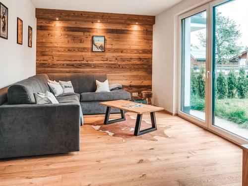 a living room with a couch and a table at ZWEITE HEIMAT - Alpine Garden Retreat in Zillertal, presented by AlpenLuxus in Fügen